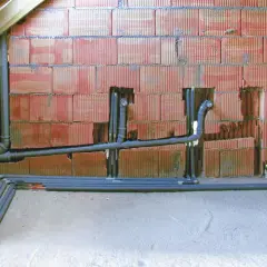 Instalacja hydrauliczna w trakcie budowy, widoczne rury i kształtki. To kluczowy etap, by wiedzieć, jak zrobić odpowietrzenie WC.